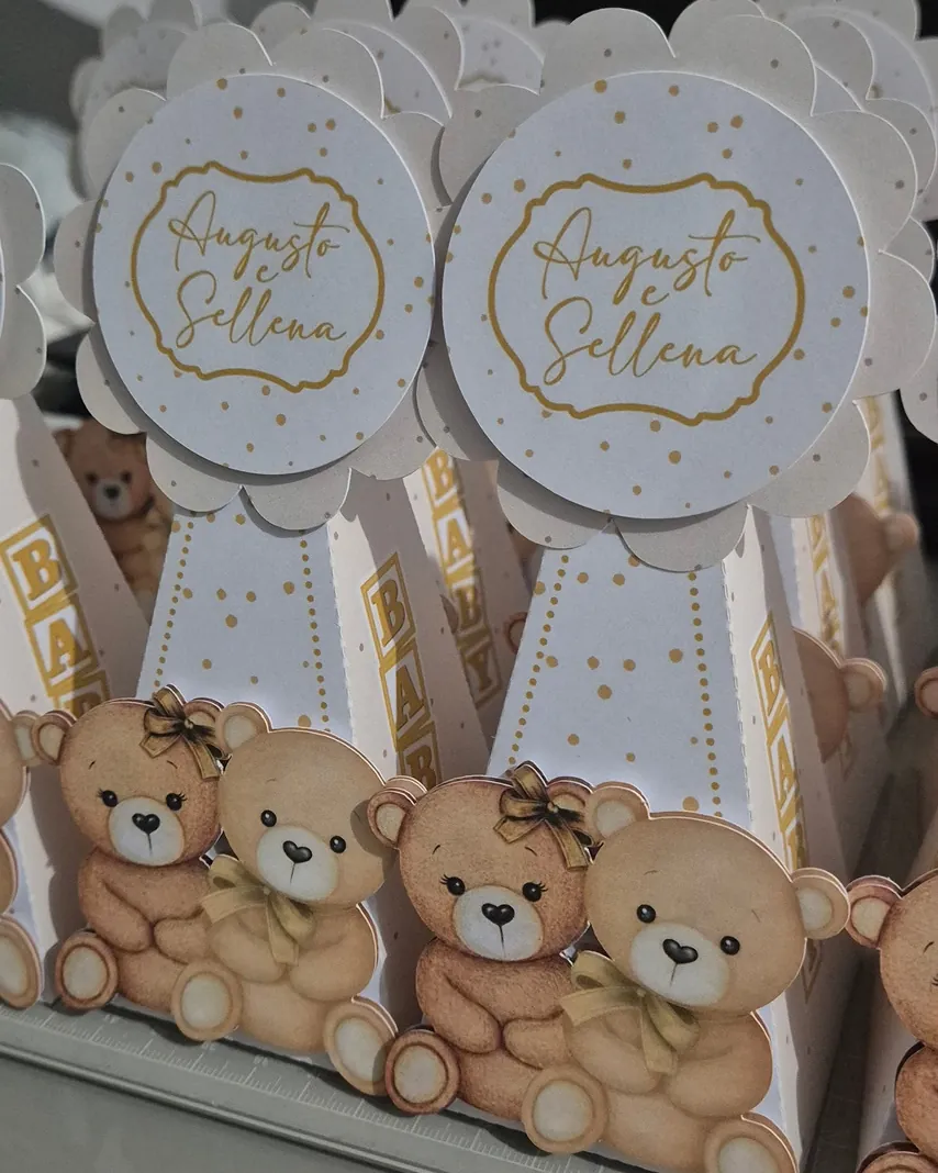 Caixinhas brancas com ursinhos em camadas e o nome Augusto e Sellena em dourado