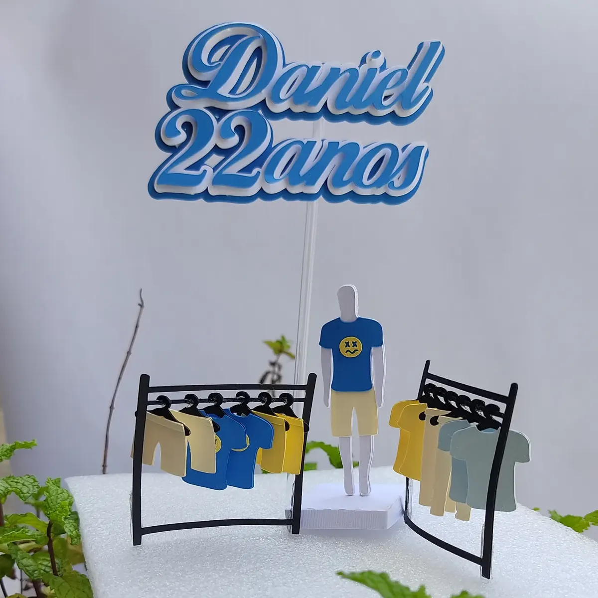 Topo Daniel 22 anos com uma arara de roupas em miniatura